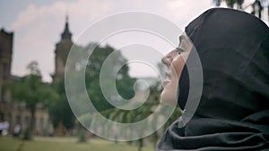 Young beautiful muslim girl in hijab is watching in sky, enjoying weather, religiuos concept