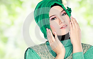 Young beautiful muslim woman with green costume wearing hijab