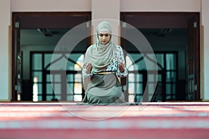 Young beautiful Muslim Woman Praying In Mosque