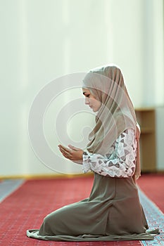 Young beautiful Muslim Woman Praying In Mosque