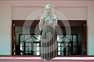 Young beautiful Muslim Woman Praying In Mosque