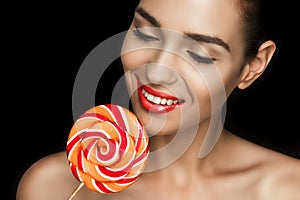 Young beautiful naked woman with red lips holding lollipop