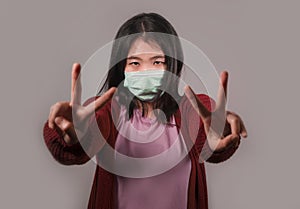 Young beautiful pacifist Asian Chinese woman in face mask doing peace fingers symbol standing for human rights respect and freedom