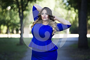 Young beautiful plus size model in blue dress outdoors, xxl woman on nature