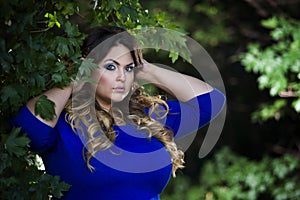 Young beautiful plus size model in blue dress outdoors, xxl woman on nature