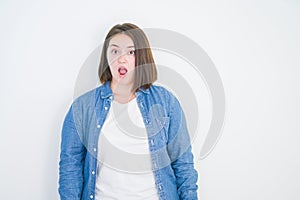 Young beautiful plus size woman over white isolated background afraid and shocked with surprise expression, fear and excited face