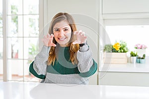 Young beautiful plus size woman wearing casual striped sweater smiling funny doing claw gesture as cat, aggressive and sexy