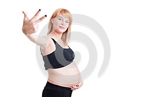 Young beautiful pregnant woman showing number three