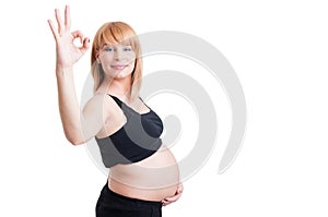 Young beautiful pregnant woman showing okay or perfect gesture