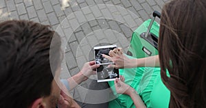 Young beautiful pregnant woman showing an ultrasound image to her husband. A couple in love is expecting a baby