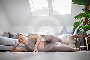 Young beautiful pregnant woman training pilates at home in her living room. Healthy lifestyle and active pregnancy and