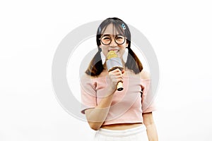 Young beautiful and pretty Asian female student holding a microphone singing with attractive smile isolated over white background.