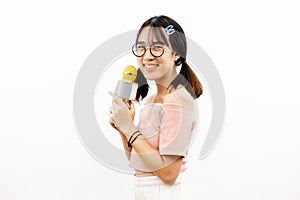 Young beautiful and pretty Asian female student holding a microphone singing with attractive smile isolated over white background.