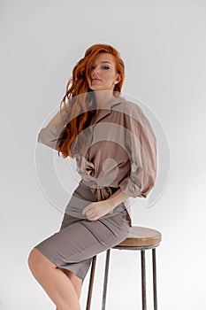 Young beautiful red-haired girl in a light shirt in the color of moko