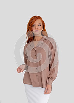 Young beautiful red-haired girl in a light shirt in the color of moko