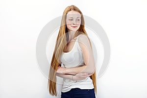 Young beautiful redhead beginner model woman in white t-shirt blue jeans practicing posing showing emotions standing against white