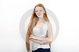 Young beautiful redhead beginner model woman in white t-shirt blue jeans practicing posing showing emotions standing against white