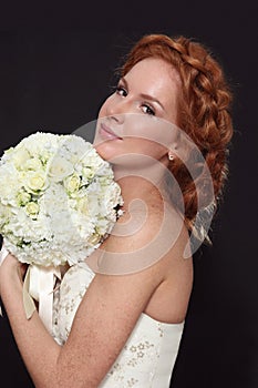 Young beautiful redhead bride with prom hairdo and bouckuet