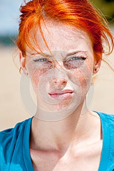 Young beautiful redhead freckled woman displeased photo