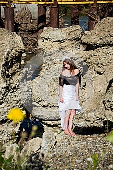 Young beautiful redhead woman in dress barefoot