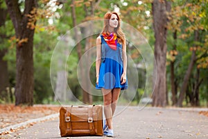 Young beautiful redhead woman with suitcase