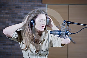 Young beautiful retro woman recording the sound