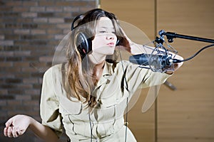 Young beautiful retro woman recording the sound