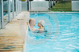 Young beautiful romantic couple is having rest in swimming pool