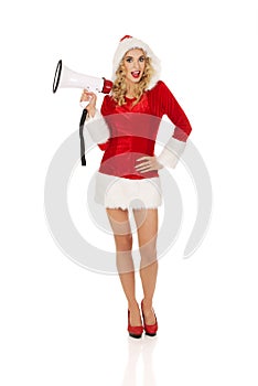 Young beautiful santa woman holding megaphone