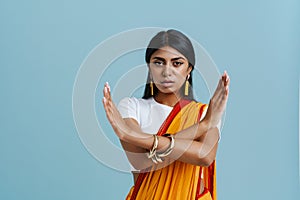 Young beautiful serious indian woman showing rejection gesture crossed arms