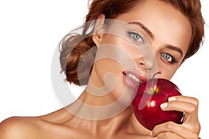 Young beautiful girl with dark curly hair, bare shoulders and neck, holding big red apple to enjoy the taste and are dieting,