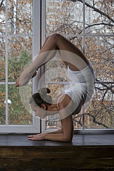 Young beautiful woman doing yoga on window