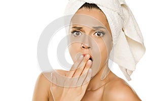Young beautiful shocked woman with towel on her head