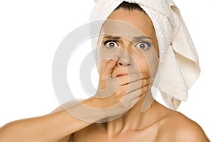 Young beautiful shocked woman with towel on her head