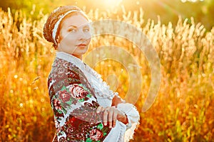A girl in a national costume at sunset