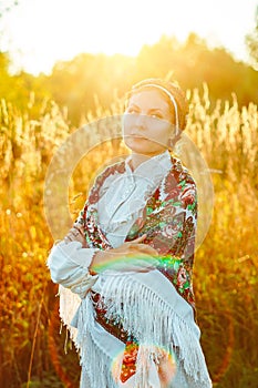 A girl in a national costume at sunset