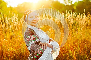 A girl in a national costume at sunset