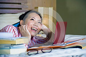 Young cute and happy nerdy Asian Korean student teenager girl in nerd glasses and hair ribbon studying at home bedroom sitting on