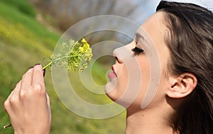 Young beautiful smells flowers