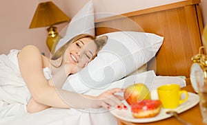 Young beautiful smiling lady waking up and having