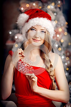 Young beautiful smiling santa woman near the Christmas tree. Fashionable luxury girl celebrating New Year. Beauty luxury trendy b