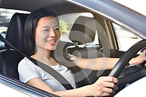 Young beautiful smiling woman driving her new car