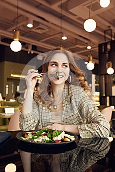 Young beautiful smiling woman eating healthy food