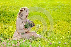 Young beautiful smiling woman in the field, on the grass. Girl r
