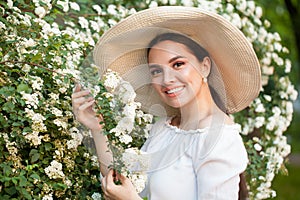 Young beautiful smiling woman with flowers outdoors