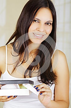 Young beautiful smiling woman holding a cardboard box that includes a menstruation cotton tampon, sanitary towel used