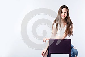 Young beautiful smiling woman with long straight hair on a gray.