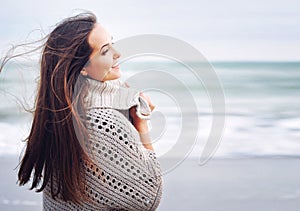 Young beautiful smiling woman portrait against ocean background