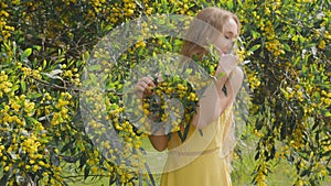 Young beautiful smiling woman in spring Australian Golden wattle trees.