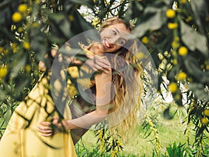 Young beautiful smiling woman in spring Australian Golden wattle trees.